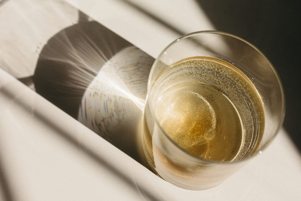water glass with sun going through it and reflecting on table